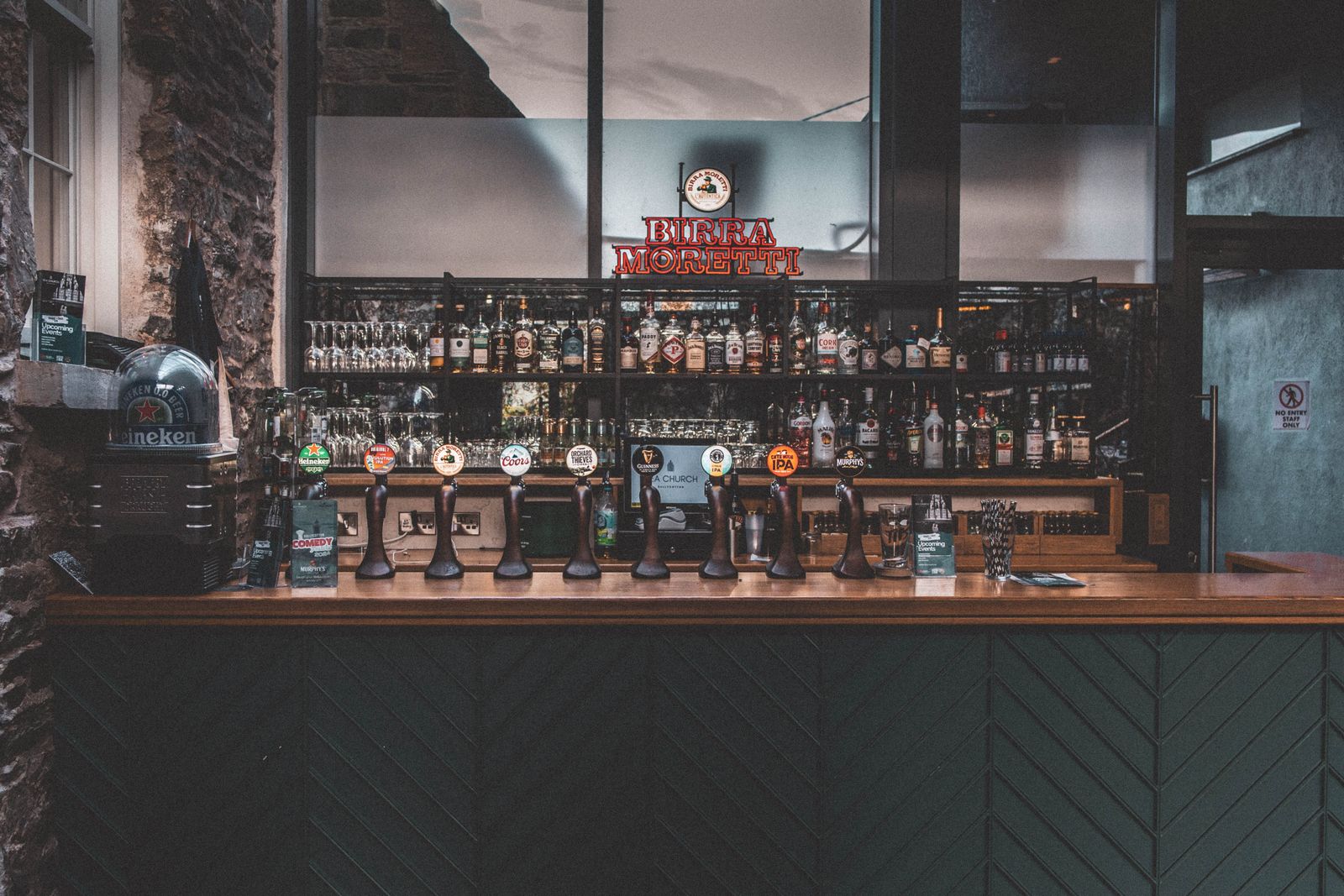 Interior of a traditional Irish pub in County Cork, Ireland, with a whiskey-lined back bar